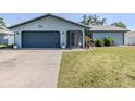 Charming one-story home featuring a two car garage, lawn, and manicured landscaping at 214 Lorraine Ave, Venice, FL 34293