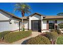 Inviting home exterior with a landscaped walkway, a palm tree, and a screened front door at 302 Woodingham Ct, Venice, FL 34292