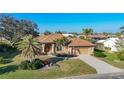 Inviting single-story home with a tile roof, palm trees, and a meticulously maintained lawn at 389 Eden Dr, Englewood, FL 34223