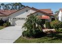 Home featuring a well-kept lawn, white stucco, a two-car garage, and mature landscaping at 4951 Summertree Rd, Venice, FL 34293