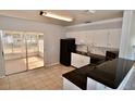 Well-lit kitchen featuring white cabinets, black appliances, and easy access to screened lanai at 5527 20Th W St, Bradenton, FL 34207