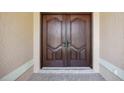 Elegant dark wood double front doors create a grand entrance to the home at 5694 Hale Rd, Venice, FL 34293