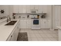 All-white kitchen with stainless steel sink, and modern appliances at 595 Back Nine Dr, Venice, FL 34285