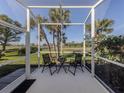 Screened patio featuring seating with a view of the green space and palm trees at 595 Back Nine Dr, Venice, FL 34285