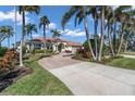 Beautiful single-story home with palm trees, brick drive, tile roof, and attached garage at 612 Cadiz Rd, Venice, FL 34285