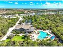 Stunning aerial view of community pool, clubhouse, and surrounding lush landscape at 6341 Milestone Loop, Palmetto, FL 34221