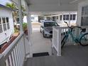 A covered carport provides parking next to the home, accessible by steps to a side deck at 749 N Green Cir, Venice, FL 34285