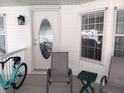 A welcoming porch with seating area, a decorative front door and a bicycle at 749 N Green Cir, Venice, FL 34285