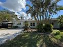 Charming single-story home with lush tropical landscaping, a shell driveway, and a quaint gazebo at 807 Lucille Ave, Nokomis, FL 34275