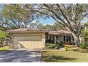 Charming single-story home with a well-manicured lawn, beautiful landscaping and an attached two-car garage at 9790 Parkwood Ct, Seminole, FL 33777