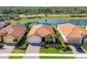 Aerial view of single Gathering home with a tile roof near a lake in a manicured community at 10181 Colubrina Dr, Venice, FL 34293