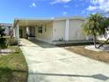 Charming single Gathering home featuring a welcoming front yard, palm trees, and covered parking at 105 Lakeview Dr, North Port, FL 34287