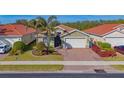 Charming single-story home featuring a two-car garage, lush landscaping, and a brick paved driveway at 11666 Parrotfish St, Venice, FL 34292