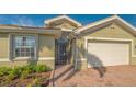 Close up of the exterior showing the arched entry, two car garage, and manicured landscaping at 11666 Parrotfish St, Venice, FL 34292