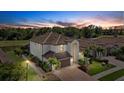 Beautiful home with a tile roof, manicured lawn, and lush tropical landscaping at 12279 Canavese Ln, Venice, FL 34293