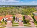 An aerial view showcasing the home's tile roof, well-manicured lawn, and neighborhood setting at 12410 Cinqueterre Dr, Venice, FL 34293