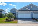 Attractive blue home with a two-car garage and landscaped front yard at 12505 Palatka Dr, Venice, FL 34293
