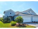 Charming blue home featuring a well-maintained lawn and two-car garage at 12505 Palatka Dr, Venice, FL 34293