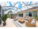 Relaxing screened-in patio with comfortable seating, perfect for outdoor entertainment and enjoying the serene backyard view at 13278 Huerta St, Venice, FL 34293