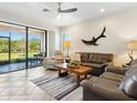 Open living room featuring a ceiling fan, a decorative shark and easy access to outdoor patio at 1342 Maseno Dr, Venice, FL 34292
