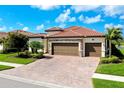 Beautiful single-Gathering home featuring a red tile roof, three-car garage, and a paved driveway at 13730 Vancanza, Venice, FL 34293