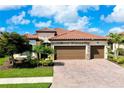 Beautiful single-Gathering home featuring a red tile roof, three-car garage, and a paved driveway at 13730 Vancanza, Venice, FL 34293
