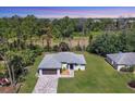 Wooded lot featuring a single-story house with a well-manicured lawn at 1449 Overhead St, North Port, FL 34288
