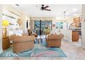 Cozy living area featuring rattan furniture, tropical rug, and a view of the screened lanai at 1545 Maseno Dr, Venice, FL 34292