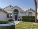 Charming front entrance with decorative plants and a tiled walkway at 1572 Jasper Ct, Venice, FL 34292