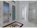 Bright foyer featuring tile floors, double glass doors, and access to other rooms at 1596 Landfall Dr, Nokomis, FL 34275