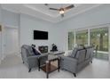 Comfortable living room with neutral decor, tile floors, and sliding doors to the lanai at 1596 Landfall Dr, Nokomis, FL 34275