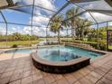 Inviting screened-in pool with a built-in spa and tranquil water views overlooking a lush landscape at 190 Montelluna Dr # North, North Venice, FL 34275