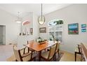 Bright dining room features a wooden table, six chairs, and a decorative chandelier at 1904 Canary Island St, Venice, FL 34292