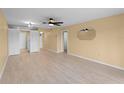 A living room with light walls, wood floors, a ceiling fan, and access to a kitchen area at 200 The Esplanade N # B10, Venice, FL 34285