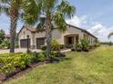 Charming home with a three car garage, desert landscaping and an inviting front porch at 26825 Weiskopf Dr, Englewood, FL 34223