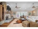 Cozy living room featuring a stone fireplace, ceiling fans and French doors to an outdoor deck at 397 Flamingo Dr, Venice, FL 34285