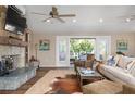 Cozy living room featuring a stone fireplace, ceiling fans and French doors to an outdoor deck at 397 Flamingo Dr, Venice, FL 34285