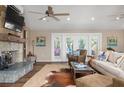 Cozy living room featuring a stone fireplace, ceiling fans and French doors to an outdoor deck at 397 Flamingo Dr, Venice, FL 34285