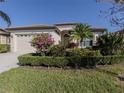 Beautiful single-story home with lush landscaping, mature trees, and well manicured lawn at 4238 Mackay Falls Ter, Sarasota, FL 34243