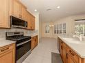 Bright kitchen featuring stainless steel appliances, light wood cabinets, and tile backsplash at 4238 Mackay Falls Ter, Sarasota, FL 34243