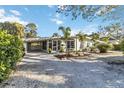 Charming single-story home featuring a carport and tropical landscaping at 432 Palmetto Ct, Venice, FL 34285