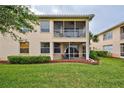 Rear exterior view with a screened patio, lush greenery, and well-maintained lawn at 4425 Corso Venetia Blvd # A20, Venice, FL 34293