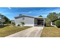 Charming gray home featuring well-maintained landscaping and a covered carport in a lovely community at 6665 Keystone Ct, North Port, FL 34287