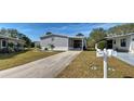 Charming gray home featuring well-maintained landscaping and a covered carport in a lovely community at 6665 Keystone Ct, North Port, FL 34287