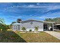 Charming gray home featuring well-maintained landscaping and a covered carport in a lovely community at 6665 Keystone Ct, North Port, FL 34287