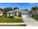 Well-maintained single-story home features a manicured lawn, front garden, and two-car garage at 707 Petrel Way, Venice, FL 34285