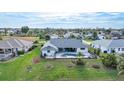 Aerial view of a single-Gathering home featuring a screened lanai, swimming pool, and well-maintained lawn at 8 Bunker Ln, Rotonda West, FL 33947