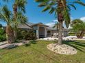 Charming single-story home featuring lush landscaping with mature palm trees and well-maintained lawn at 8 Bunker Ln, Rotonda West, FL 33947