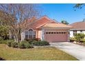 Charming home with meticulous landscaping, a tile roof and a pink two car garage at 805 Derbyshire Dr, Venice, FL 34285