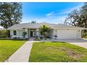 Inviting single-story home with a well-manicured lawn and charming landscaping, creating an attractive and welcoming facade at 1358 Ewing St, Nokomis, FL 34275